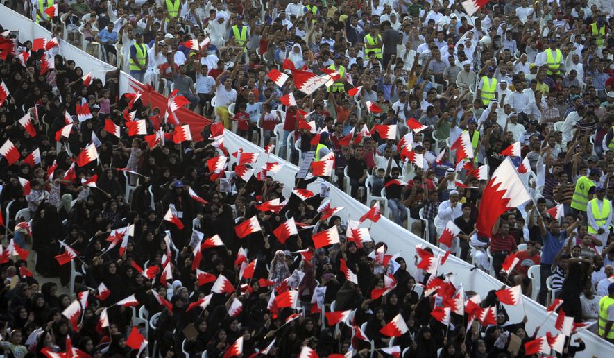 FILE- In this Friday, Sept. 30, 2011 file photo, Bahraini anti-government protesters wave flags and chant during a rally of thousands organized by Al-Wefaq, the largest Shiite opposition party, to demand greater freedoms in Quraya, Bahrain. Bahrain has again allowed agents of its domestic spy service to make arrests, reversing a key reform recommended in the wake of the crackdown that followed its 2011 Arab Spring protests. (AP Photo/Hasan Jamali, File)