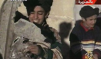 In this image made from video broadcast by the Qatari-based satellite television station Al-Jazeera Wednesday, Nov. 7, 2001, a young boy, left, identified as Hamza bin Laden holds what the Taliban says is a piece of U.S. helicopter wreckage in Ghazni, Afghanistan on Monday, Nov. 5, 2001. The Obama administration has announced terrorism-related sanctions against a son of Sept. 11 mastermind Osama bin Laden. The State Department says Hamza bin Laden has been “determined to have committed, or pose a serious risk of committing, acts of terrorism that threaten the security of U.S. nationals or the national security.”  (AP Photo/Al-Jazeera via APTN) ** TV OUT **