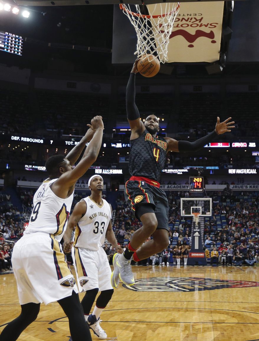 Atlanta Hawks forward Paul Millsap (4) drives to the basket between New Orleans Pelicans forward Terrence Jones (9), forward Dante Cunningham (33) and guard Tyreke Evans (1) in the first half of an NBA basketball game in New Orleans, Thursday, Jan. 5, 2017. (AP Photo/Gerald Herbert)