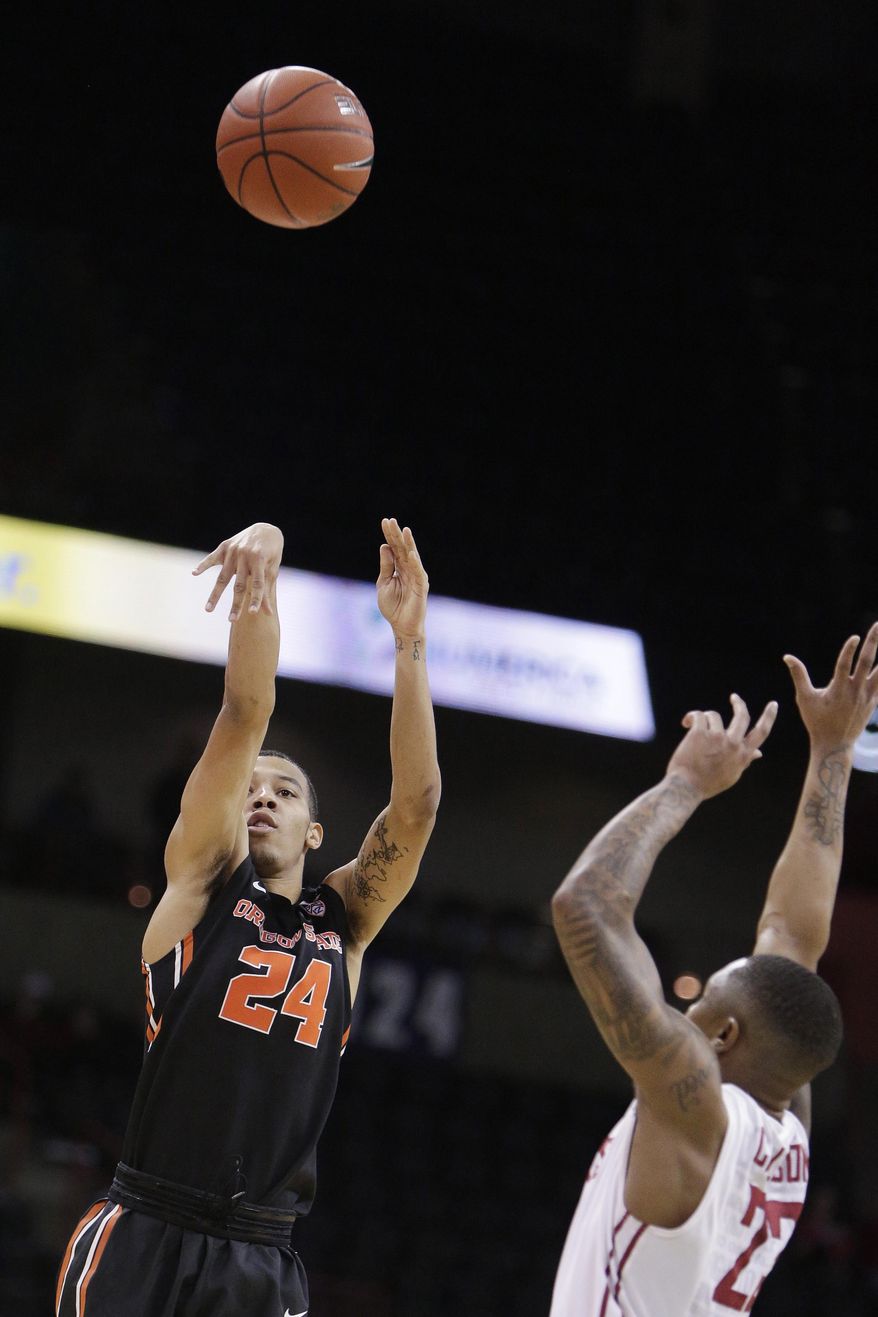 Oregon State guard Kendal Manuel (24) shoots while defended by Washington State guard Charles Callison during the first half of an NCAA college basketball game in Spokane, Wash., Wednesday, Jan. 4, 2017. (AP Photo/Young Kwak)