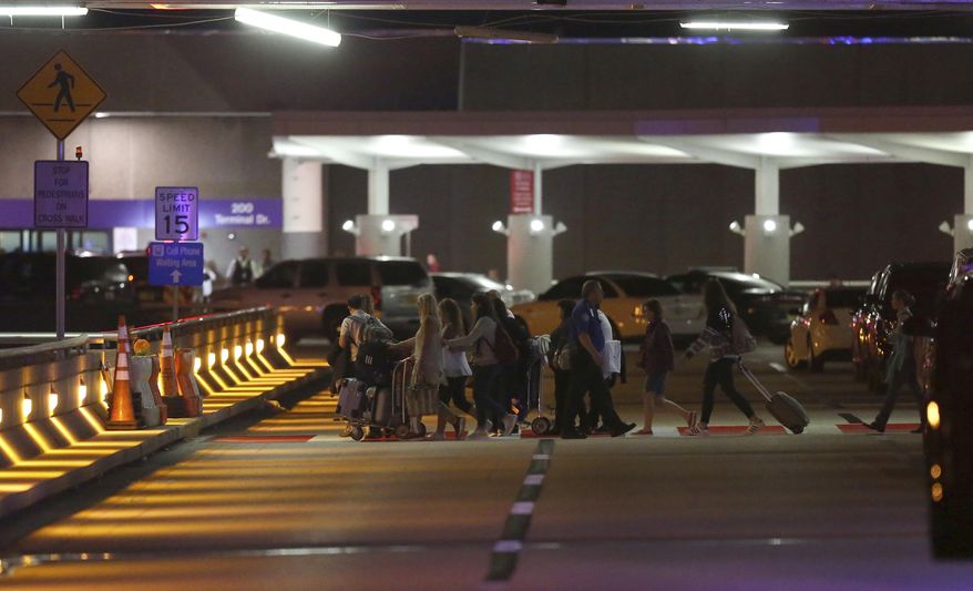 Employees and passengers walk into the parking garage near the scene of a deadly shooting at Fort Lauderdale–Hollywood International Airport, Friday, Jan. 6, 2017, in Fort Lauderdale, Fla. An Army veteran who complained that the government was controlling his mind drew a gun from his checked luggage on arrival at the Fort Lauderdale airport and opened fire in the baggage claim area Friday, killing several people and wounding others, authorities said. (David Santiago/El Nuevo Herald via AP)