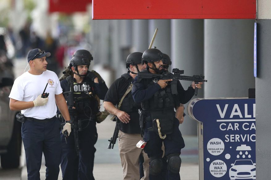 Law enforcement officers walk around Fort Lauderdale-Hollywood International Airport, Friday, Jan. 6, 2017, in Fort Lauderdale, Fla. A gunman opened fire in the baggage claim area at the airport Friday, killing several people and wounding others before being taken into custody in an attack that sent panicked passengers running out of the terminal and onto the tarmac, authorities said. (David Santiago/El Nuevo Herald via AP)