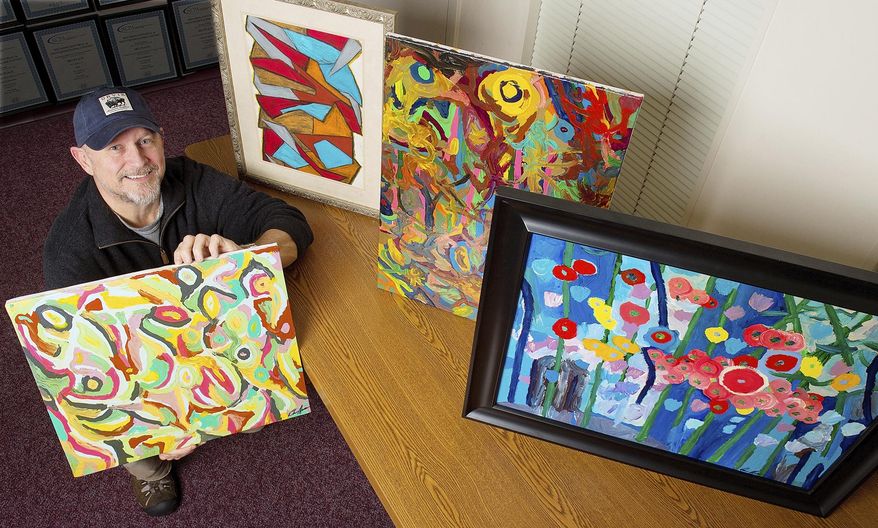 Darren Moore poses with some of his abstract paintings on Tuesday, Jan. 3, 2017, in Lexington, N.C. that he began creating as a hobby about eight years ago. Shown are samples of oil pastels, upper left, and acrylics. (Donnie Roberts/The Dispatch via AP)