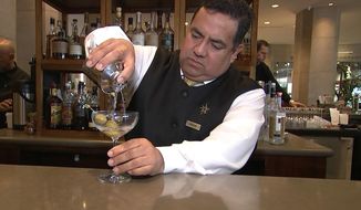 This Jan. 3, 2017 image taken from video shows Beverly Hilton hotel bartender Oscar Zuleta mixing drinks at the hotel in Beverly Hills, Calif. Zuleta has toasted with Sean Connery, gotten a head rub from Tom Hanks, shared a selfie with Jessica Alba while working previous Golden Globe Awards. The 48-year-old hotel staffer keeps the drinks flowing at the awards circuit&#39;s booziest gathering. (AP Photo/Rick Taber)