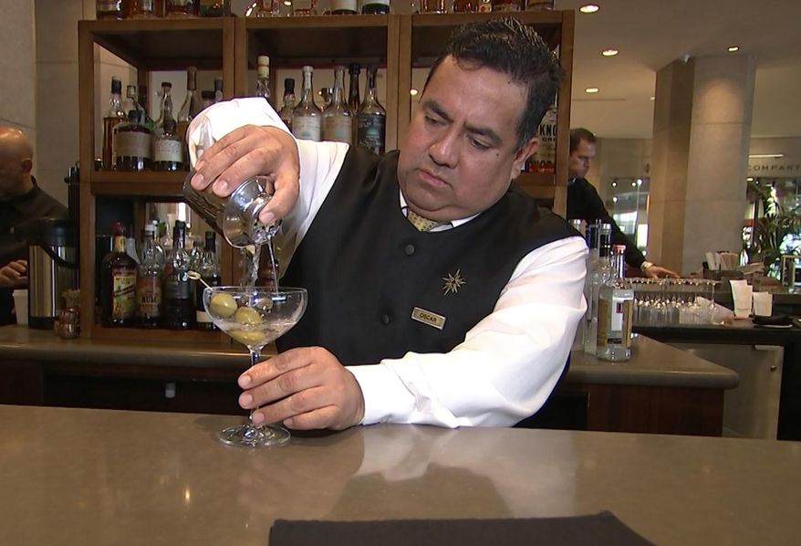 This Jan. 3, 2017 image taken from video shows Beverly Hilton hotel bartender Oscar Zuleta mixing drinks at the hotel in Beverly Hills, Calif. Zuleta has toasted with Sean Connery, gotten a head rub from Tom Hanks, shared a selfie with Jessica Alba while working previous Golden Globe Awards. The 48-year-old hotel staffer keeps the drinks flowing at the awards circuit's booziest gathering. (AP Photo/Rick Taber)