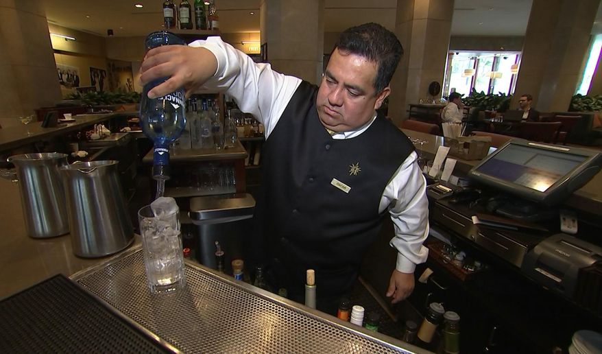 This Jan. 3, 2017 image taken from video shows Beverly Hilton hotel bartender Oscar Zuleta mixing drinks at the hotel in Beverly Hills, Calif. Zuleta has toasted with Sean Connery, gotten a head rub from Tom Hanks, shared a selfie with Jessica Alba while working previous Golden Globe Awards. The 48-year-old hotel staffer keeps the drinks flowing at the awards circuit's booziest gathering. (AP Photo/Rick Taber)
