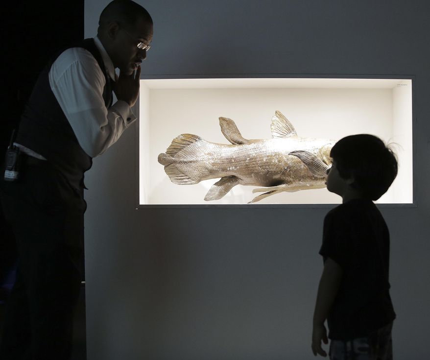 In a Tuesday, Dec. 6, 2016 photo, James Washington, the Houston Museum of Natural Science's most popular tour guide, answers questions from Ajay Selva, 4, in Houston. Washington's tours are a blend of science, jokes and pop culture references. (Elizabeth Conley//Houston Chronicle via AP)