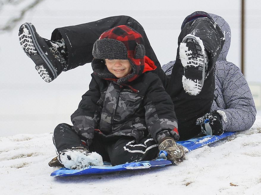 Beckett Thomas and Amaya Kindle sled down a hill at The Greens of North Hills golf course in Sherwood, Ark., on Friday Jan. 6, 2017, after a light snow fell across central Arkansas overnight closing many schools, buisnesses and roads. (Benjamin Krain/The Arkansas Democrat-Gazette via AP)