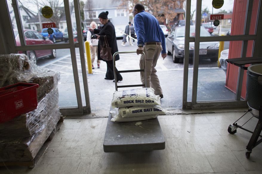 Joe Williams, right, with Taylor's Do It Center in Norfolk, Va.,, helps Leslie Councill, of Councill Realty and Management, load the stores three bag limit of rock salt into her truck, Friday afternoon Jan. 6, 2017. The store has sold more than 800 bags of rock salt and are currently out of snow shovels but are expecting over one hundred snow shovels to be delivered to the store later in the day. (L. Todd Spencer/The Virginian-Pilot via AP)