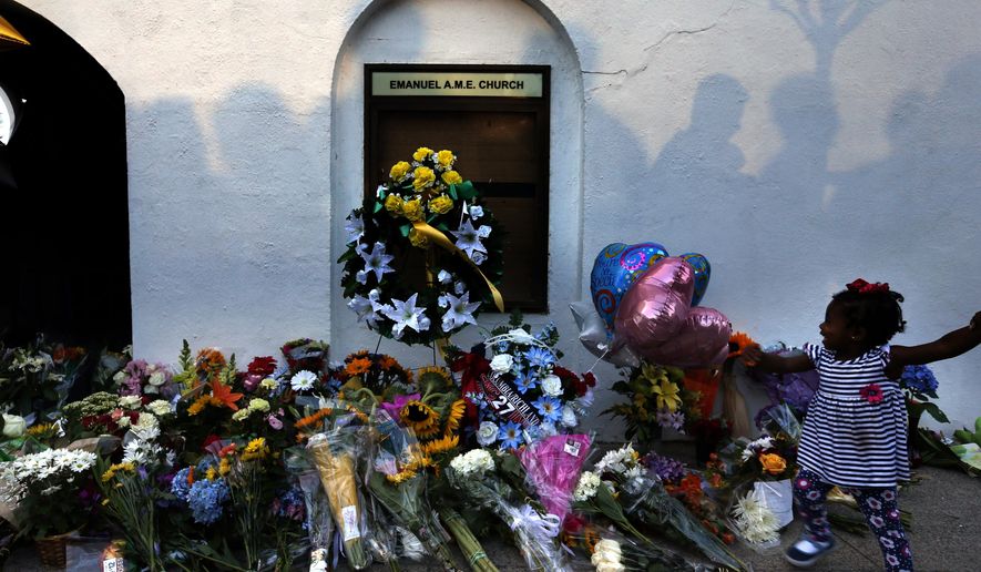 FILE-In this Thursday, June 18, 2015 file photo, mourners pass by a make-shift memorial on the sidewalk in front of the Emanuel AME Church following a shooting by Dylann Roof in Charleston, S.C. A federal jury will consider whether Roof should be sentenced to death or life in prison for killing nine black church members in a racially motivated attack. (AP Photo/Stephen B. Morton, File)