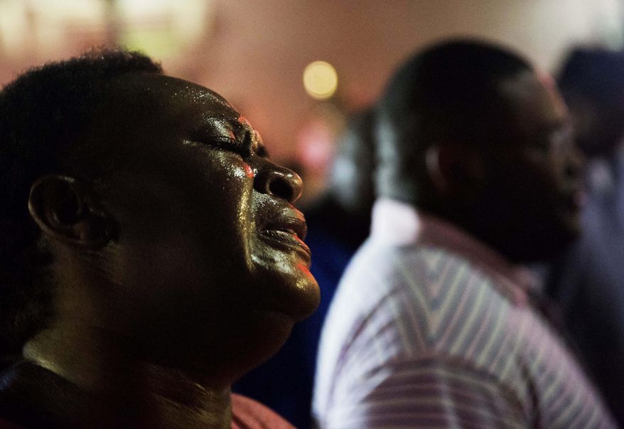 FILE-In this Thursday, June 18, 2015 file photo, Lisa Doctor joins a prayer circle down the street from the Emanuel AME Church where nine people were killed by Dylann Roof in Charleston, S.C. A federal jury will consider whether Roof should be sentenced to death or life in prison for killing nine black church members in a racially motivated attack. (AP Photo/David Goldman, File)