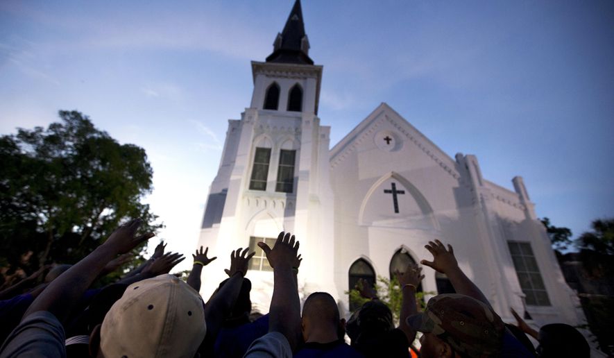FILE -In this Friday, June 19, 2015 file photo, the men of Omega Psi Phi Fraternity Inc. lead a crowd of people in prayer outside the Emanuel AME Church, after a memorial for the nine people killed by Dylann Roof in Charleston, S.C. A federal jury will consider whether Roof should be sentenced to death or life in prison for the racially motivated attack.(AP Photo/Stephen B. Morton, File)
