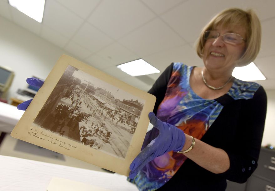 ADVANCE FOR USE SATURDAY, JAN. 7 - In this Dec. 12, 2016 photo, Peggy Ford Waldo smiles as she pulls one of the photos used in a book she wrote with the help of the Greeley History Museum at the musuem in Greeley, Colo. Waldo has worked for the Greeley History Museum since 1979 and is considered the city's most knowledgeable historian. (Joshua Polson /The Greeley Tribune via AP)
