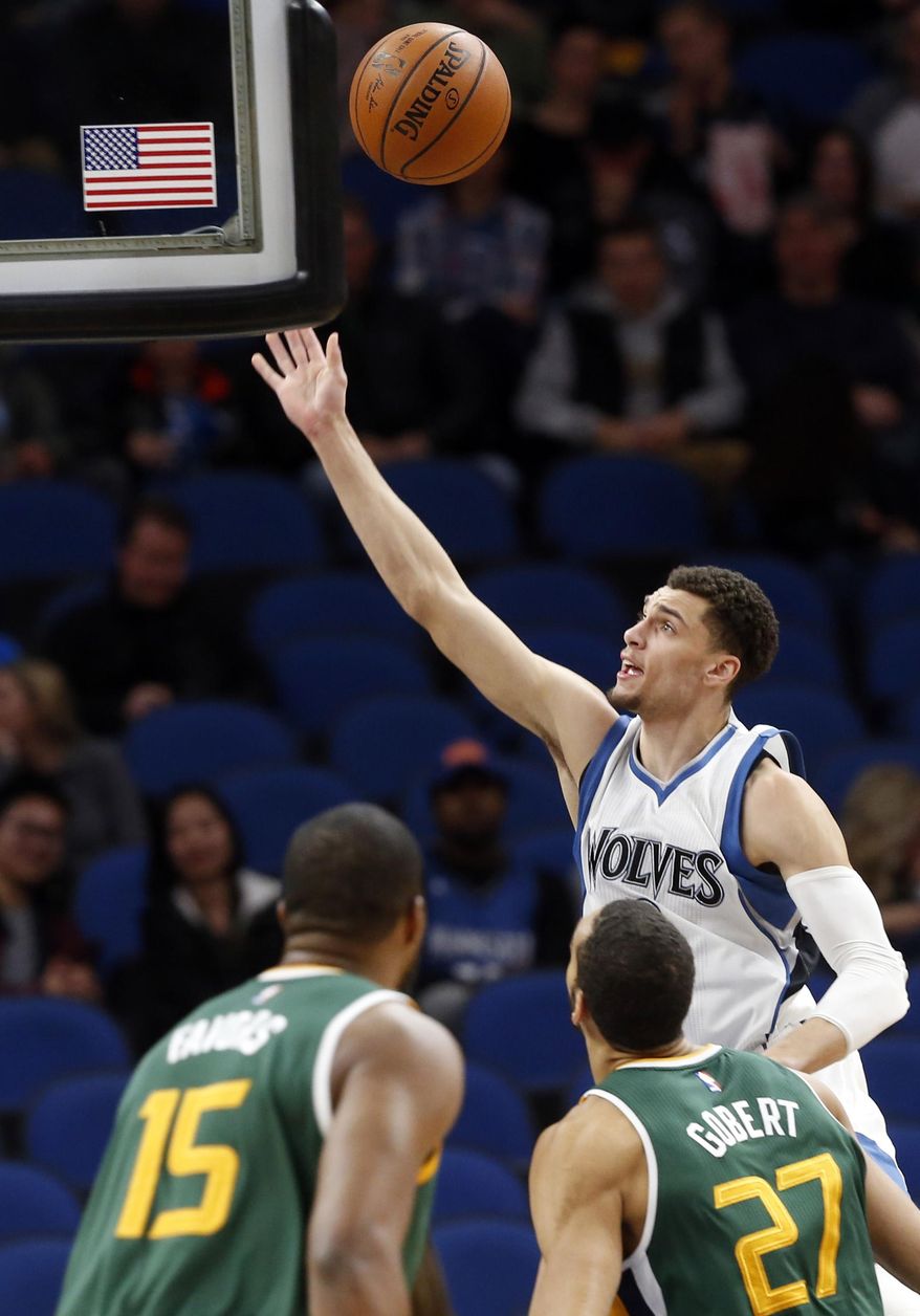 Minnesota Timberwolves' Zach LaVine, top, shoots as Utah Jazz's Derrick Favors, left, and Rudy Gobert, of France, look on during the first quarter of an NBA basketball game Saturday, Jan. 7, 2017, in Minneapolis. (AP Photo/Jim Mone)