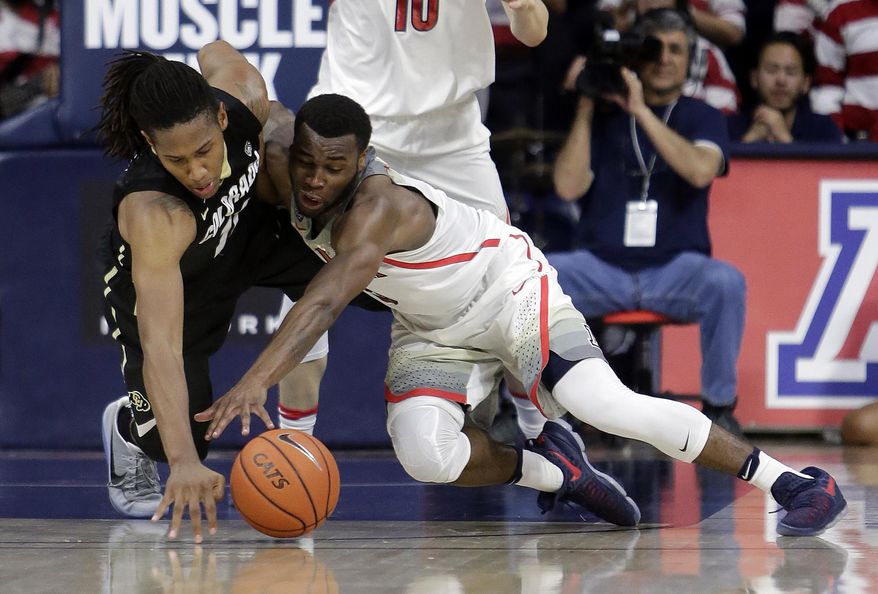 Colorado guard Xavier Johnson, left, and Arizona guard Kadeem Allen battle for a loose ball during the second half of an NCAA college basketball game, Saturday, Jan. 7, 2017, in Tucson, Ariz. Arizona defeated Colorado 82-73. (AP Photo/Rick Scuteri)