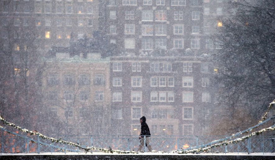 A person crosses the pedestrian bridge in the Public Garden during a winter storm in Boston, Saturday, Jan. 7, 2017. (AP Photo/Michael Dwyer)