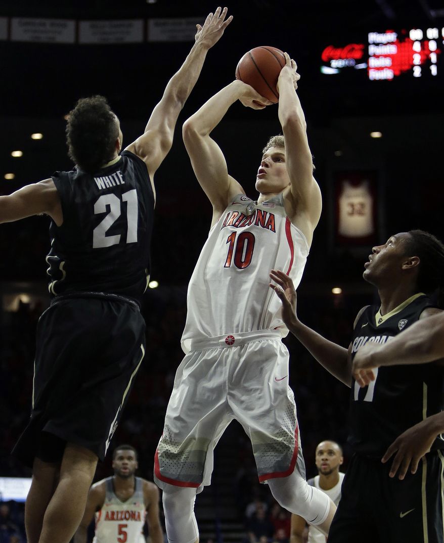 Arizona forward Lauri Markkanen (10) shoots between Colorado guard Derrick White (21) and Xavier Johnson (11) during the second half of an NCAA college basketball game, Saturday, Jan. 7, 2017, in Tucson, Ariz. Arizona defeated Colorado 82-73. (AP Photo/Rick Scuteri)