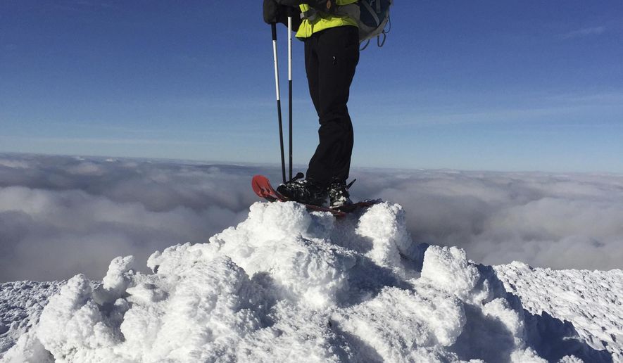 In this Dec. 6, 2016 photo, Sue Johnston poses on top of Mount Eisenhower in the White Mountains of New Hampshire. Johnston is believed to be the first person to complete an ambitious hiking challenge in the White Mountains in a single year. The Concord Monitor reported Johnston hiked every one of New Hampshire's 4,000-foot mountains in every single month of the year in 2016. The challenge is known as "the Grid" and takes most hikers years to complete. (Chris Scott via AP)