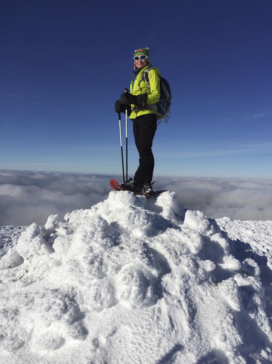 In this Dec. 6, 2016 photo, Sue Johnston poses on top of Mount Eisenhower in the White Mountains of New Hampshire. Johnston is believed to be the first person to complete an ambitious hiking challenge in the White Mountains in a single year. The Concord Monitor reported Johnston hiked every one of New Hampshire's 4,000-foot mountains in every single month of the year in 2016. The challenge is known as "the Grid" and takes most hikers years to complete. (Chris Scott via AP)