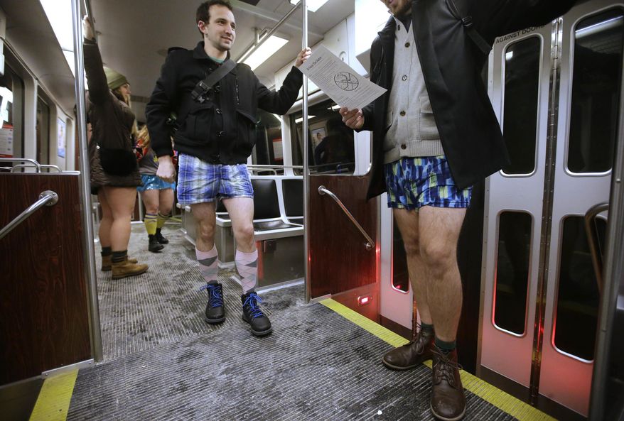 Steven Blomquist, of Somerville, Mass., center, speaks with Tim Lewis, of Boston, right, while wearing no pants as they ride a subway train during the event "No Pants Subway Ride" Sunday, Jan. 8, 2017, in Boston. The annual event was started in 2002 in New York. Organizers say pants-less subway rides are scheduled to take place this year in dozens of cities around the world. (AP Photo/Steven Senne)