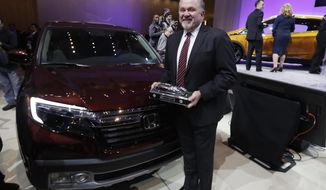 President and CEO of Honda North America John Mendel stands next to the Honda Ridgeline after winning the truck of the year at the North American International Auto show, Monday, Jan. 9, 2017, in Detroit. (AP Photo/Carlos Osorio)