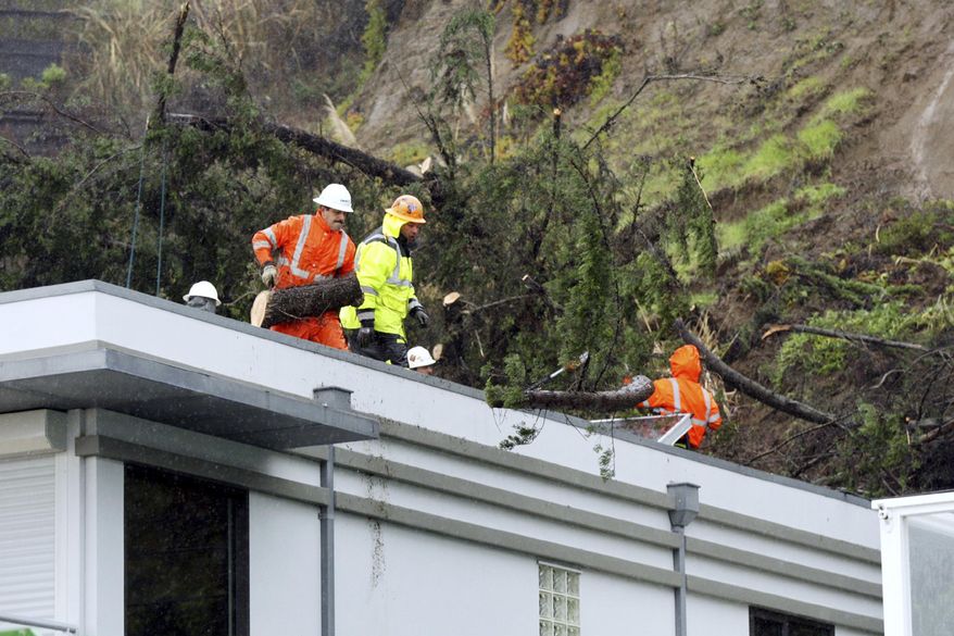 Tree workers remove a tree that had fallen on a rooftop in Aptos, Calif., Sunday, Jan. 8, 2017. Rivers are rising and winds are whipping up as a massive storm arrives in Northern California and is expected to push into Nevada by the evening. (Dan Coyro/The Santa Cruz Sentinel via AP)