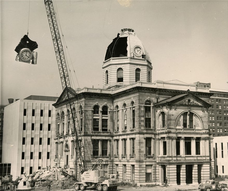 This June 30, 1964 photo shows a crane removing the 1878 Seth Thomas clock from the old Peoria County Courthouse in Peoria, Ill. Peoria businessman Foster Vachon saved the Seth Thomas clock at his own expense shortly before the old Courthouse was torn down. The clock now resides at the Peoria Riverfront Museum in Peoria, Ill. (Archive Photo/Journal Star via AP)