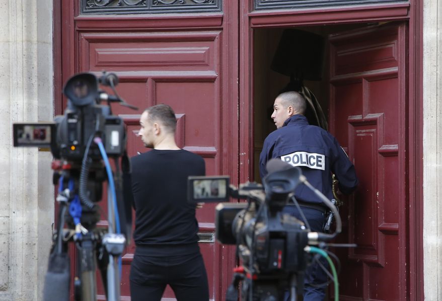 FILE - In this Oct.3, 2016 file photo, a French police officer enters the residence of Kim Kardashian West in Paris. Paris police Monday Jan.9, 2017 say 16 people have been arrested over Kim Kardashian jewelry heist. (AP Photo/Michel Euler, File)