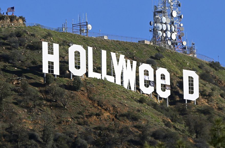 FILE - In this Jan. 1, 2017, file photo, the famed Hollywood sign is seen altered to read "HOLLYWeeD," in Los Angeles. Los Angeles police said in a statement that 30-year-old Zachary Cole Fernandez was arrested Monday, Jan. 9, 2017, in connection with the vandalism. Police say Fernandez turned himself in with his attorney and was booked on suspicion of misdemeanor trespassing. (AP Photo/Damian Dovarganes, File)