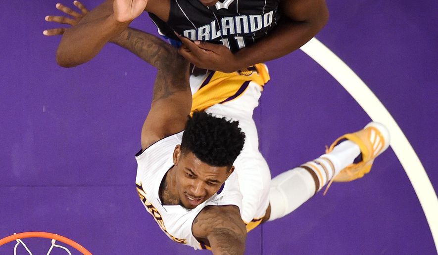 Los Angeles Lakers guard Nick Young, bottom, shoots as Orlando Magic center Bismack Biyombo, of the Republic of Congo, defends during the first half of an NBA basketball game, Sunday, Jan. 8, 2017, in Los Angeles. (AP Photo/Mark J. Terrill)