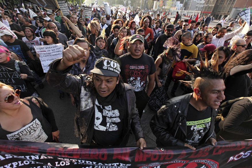 Protesters from an anarchist group shout slogans as they march against fuel price hikes in Mexico City, Monday, Jan. 9, 2017. Largely peaceful protests against the fuel price increases continued nationwide in Mexico, and looting seen last week largely subsided. The protests have left hundreds of businesses looted and more than 1,500 detained.(AP Photo/Marco Ugarte)