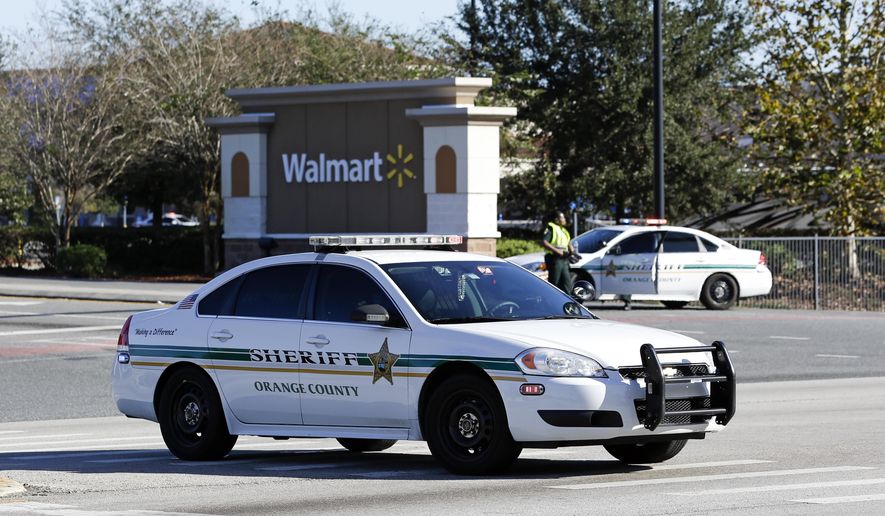 Orange County Sheriff&#39;s officers block the entrance to a Walmart near the scene where a police officer was shot, Monday, Jan. 9, 2017, in Orlando, Fla. Orlando police say the officer who was shot while on duty has died; a manhunt is underway for the suspect.(AP Photo/John Raoux)