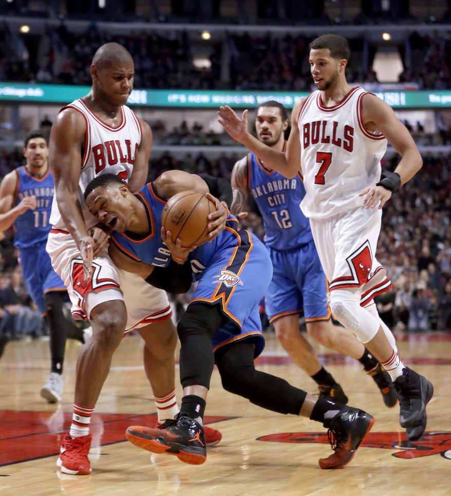 Oklahoma City Thunder's Russell Westbrook, center, drives on Chicago Bulls' Cristiano Felicio, left, as Steven Adams (12) and Michael Carter-Williams (7) watch during the first half of an NBA basketball game Monday, Jan. 9, 2017, in Chicago. (AP Photo/Charles Rex Arbogast)