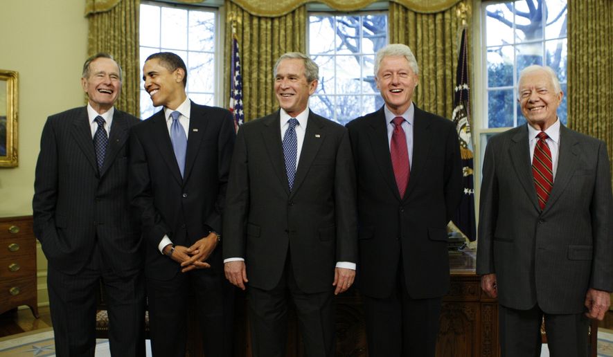FILE - In this Jan. 7, 2009, file photo President-elect Barack Obama is welcomed by President George W. Bush for a meeting at the White House in Washington with former presidents, from left, George H.W. Bush, Bill Clinton and Jimmy Carter. More than half of Americans view President Barack Obama favorably as he leaves office, a new poll shows, but Americans remain deeply divided over his legacy. Less than half of Americans say they’re better off eight years after his election or that Obama brought the country together. (AP Photo/J. Scott Applewhite, File)