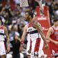 Washington Wizards guard John Wall (2) reacts after he scored during the closing seconds of an NBA basketball game against the Chicago Bulls, Tuesday, Jan. 10, 2017, in Washington. Also seen is Chicago Bulls guard Rajon Rondo (9) and Washington Wizards forward Kelly Oubre Jr. (12). The Wizards won 101-99. (AP Photo/Nick Wass)