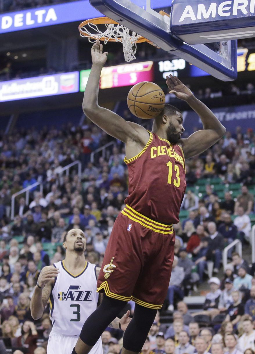 Cleveland Cavaliers center Tristan Thompson (13) dunks the ball as Utah Jazz guard George Hill (3) looks on in the first half during an NBA basketball game Tuesday, Jan. 10, 2017, in Salt Lake City. (AP Photo/Rick Bowmer)