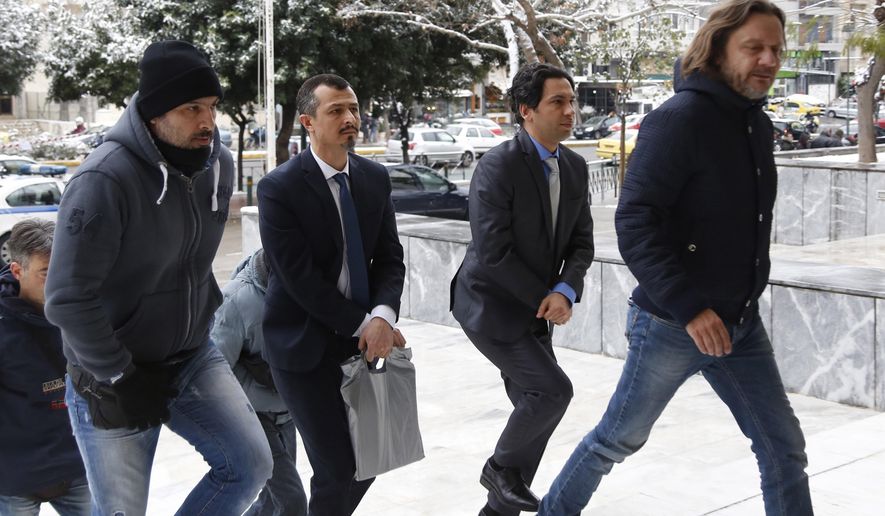 Handcuffed Turkish military officers, center, are escorted by plain-clothed police officers as they arrive at the Supreme Court in Athens, on Tuesday, Jan. 10, 2017. A prosecutor at Greece&#39;s Supreme Court recommended on Tuesday the court reject an extradition request for the first two of eight Turkish servicemen who fled to Greece after a failed July military coup in their country. (Stelios Misinas/Eurokinissi via AP)