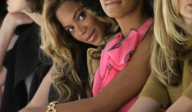 FILE - In this Sept. 13, 2011, file photo, Beyonce Knowles, center left, sits with her sister Solange Knowles during the presentation of Vera Wang's Spring 2012 collection in New York. Beyonce interviewed Solange for Interview magazine in a conversation published online on Jan. 10, 2017. (AP Photo/Bebeto Matthews, File)