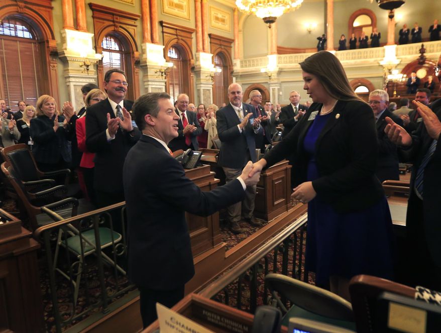 Gov. Sam Brownback shakes hands with Rep. Stephanie Clayton, R-Overland Park before delivering his state of the state address to a joint session of the Kansas legislature in Topeka, Kan., Tuesday, Jan. 10, 2017. (AP Photo/Orlin Wagner)