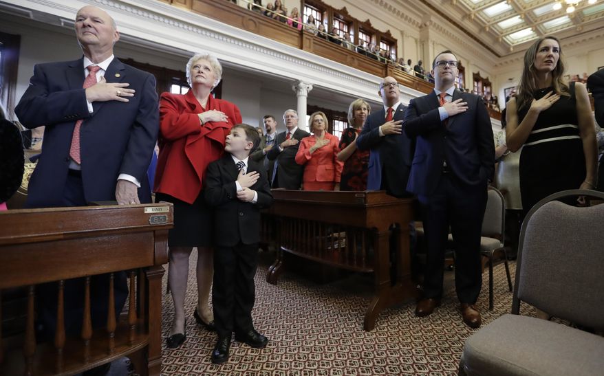 Ben Scogin, center, joins his grandfather, Rep. John Raney, R-College Station, left, in the pledge during the opening of the 85th Texas Legislative session at the Texas State Capitol, Tuesday, Jan. 10, 2017, in Austin, Texas. (AP Photo/Eric Gay)