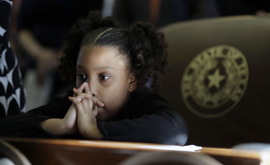 Marcina Thomas, granddaughter of Senfronia Thomas, D-Houston, joins in the closing prayer during the opening of the 85th Texas Legislative session in the House Chamber at the Texas State Capitol, Tuesday, Jan. 10, 2017, in Austin, Texas. (AP Photo/Eric Gay)