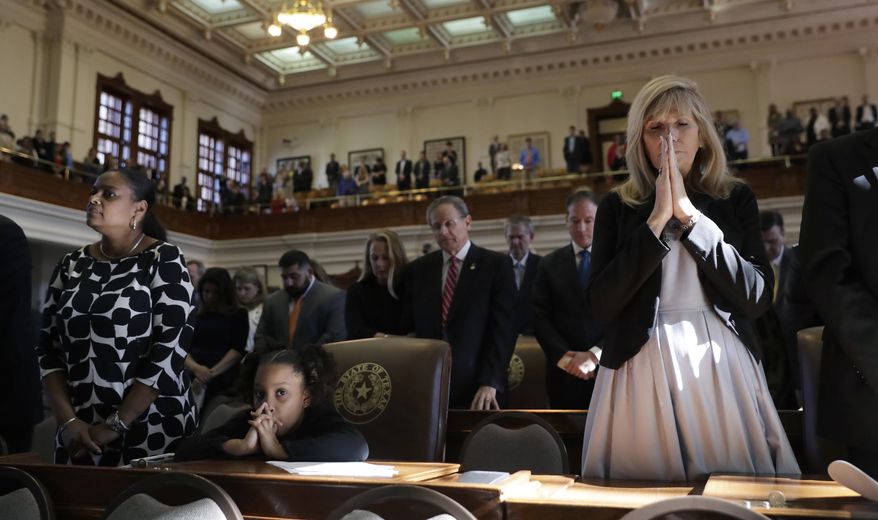 Marcina Thomas, second from left, and Lynn Sullivan, right, join in the closing prayer during the opening of the 85th Texas Legislative session in the House Chamber at the Texas State Capitol, Tuesday, Jan. 10, 2017, in Austin, Texas. (AP Photo/Eric Gay)