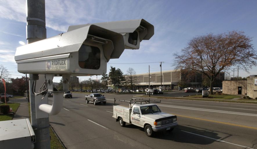 FILE – In this Nov. 10, 2014, file photo, traffic flows past a photo enforcement traffic camera in Dayton, Ohio. Attorneys for the city of Dayton will urge state Supreme Court justices on Tuesday, Jan. 10, 2017, to reject a requirement that a police officer be present when cameras are used to generate red-light or speeding citations, part of a state law that took effect in 2015. (Lisa Powell/Dayton Daily News via AP, File)