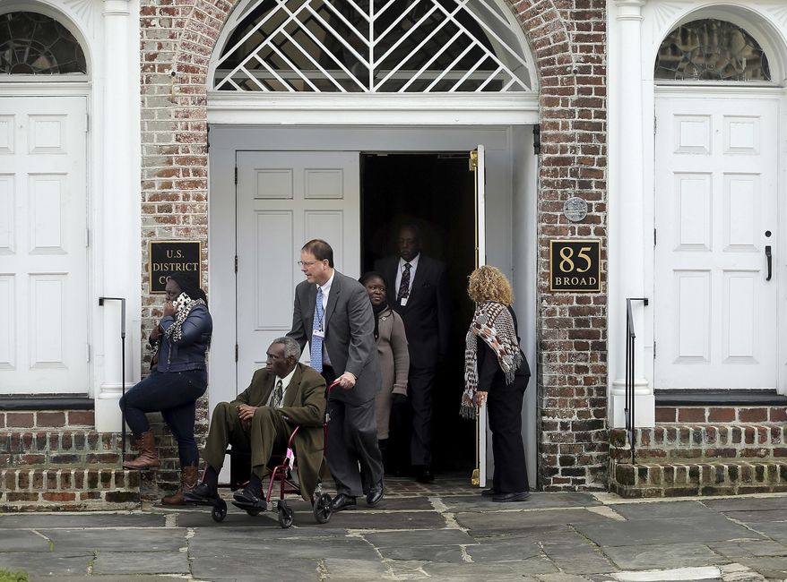 The Rev. Spike Coleman pushes John Pinckney, father of the Rev. Clementa Pinckney, one of the Emanuel Church shooting victims, as they leave leaves the U.S. District Court on Tuesday, Jan. 10, 2017, in Charleston, S.C. Grace Beahm/The Post And Courier via AP)