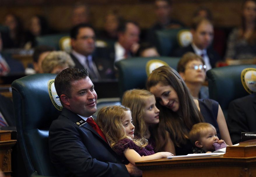 New House Minority Leader Patrick Neville, R-Castle Rock, left, sits with his family, daughters Hannah, 5, Mary Katelyn, 8, Lydia, 8 months, and wife Kristi during the opening session of the 2017 Colorado Legislature, at the Capitol, in Denver, Wednesday Jan. 11, 2017. The Colorado Democratic House and Republican Senate are waiting for cues from Washington and from Democratic Gov. John Hickenlooper about the priorities this year. (AP Photo/Brennan Linsley)