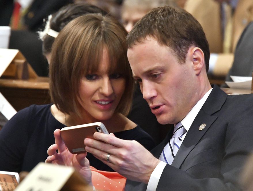 New Speaker of the House, Tom Leonard, R-DeWitt, checks a message with his wife, Jenell, as the Michigan House of Representatives convenes to start the new year at the Capitol in Lansing, Mich., Wednesday, Jan. 11, 2017. (Dale G. Young/Detroit News via AP)