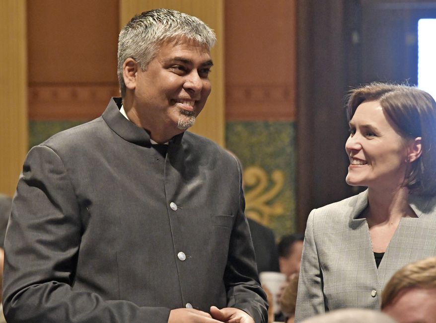 House minority leader Rep, Sam Singh, D-Detroit chats as the Michigan House of Representatives convenes to start the new year at the Capitol in Lansing, Mich., Wednesday, Jan. 11, 2017. (Dale G. Young/Detroit News via AP)