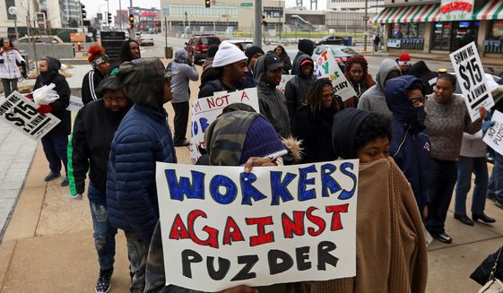 About 50 fast food workers protest the nomination of former Hardees CEO Andrew Puzder to lead the U.S. Department of Labor on Thursday, Jan. 12, 2017, outside the current headquarters of the fast food chain in downtown St. Louis. Fast food workers claim Puzder is unfit for the position because of his policies toward employees as Hardees boss. (Christian Gooden/St. Louis Post-Dispatch via AP)