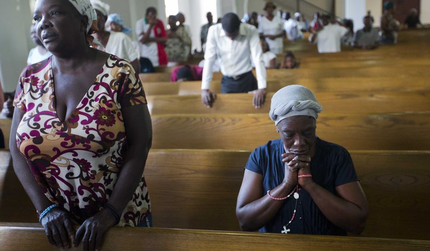 In this Thursday, Jan. 12, 2017 photo, residents attend a Mass during the 7th anniversary of the earthquake in Port-au-Prince, Haiti. Many Haitians lit candles and offered prayers Thursday to remember relatives and neighbors who died in a catastrophic earthquake that struck near the Caribbean nation&#x27;s capital seven years ago.(AP Photo/Dieu Nalio Chery)