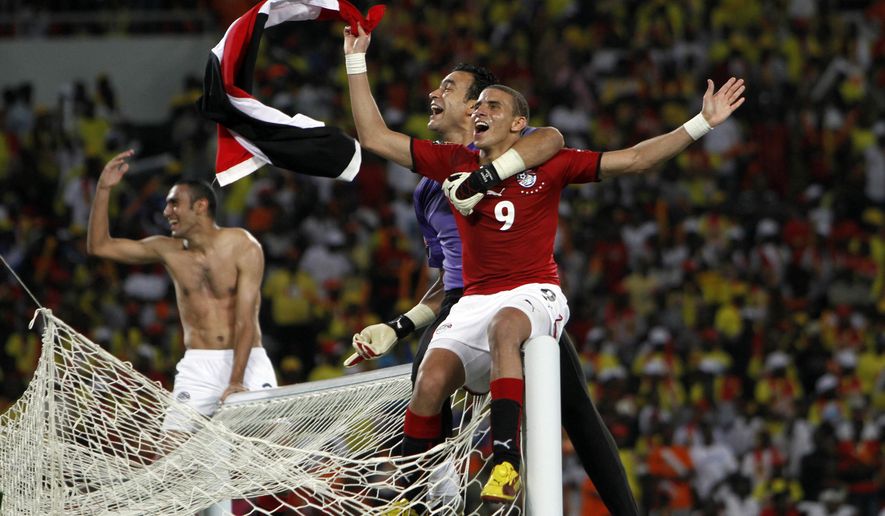 FILE - In this Sunday, Jan. 31, 2010 file photo, Egypt soccer players sit atop the goal posts as they celebrate their victory in the African Cup of Nations final soccer match against Ghana, in Luanda, Angola. The African Cup of Nations returns to Gabon for the second time in five years with the kickoff on Saturday Jan. 14, 2017 and the final on Feb. 5. (AP Photo/Darko Bandic, File)